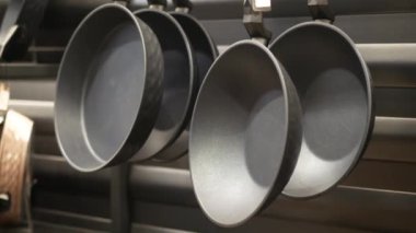 Modern ve şık kızartma tavaları çağdaş bir mutfak ortamında güzelce asılı.