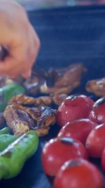 Lezzetli domatesleri ve canlı biberleri ızgaranın yanında ustalıkla ızgarada pişirmek.