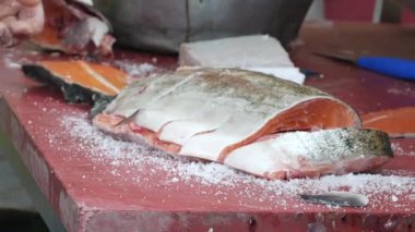 Bozulmamış bir çalışma yerinde balık kesme ve hazırlama sanatını ustaca icra ediyor.