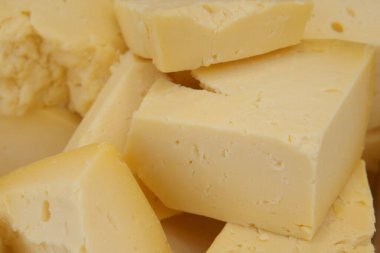 Yemek pişirmede çeşitli kullanım alanları için taze sarı peynir küplerinin yakın plan çekimi