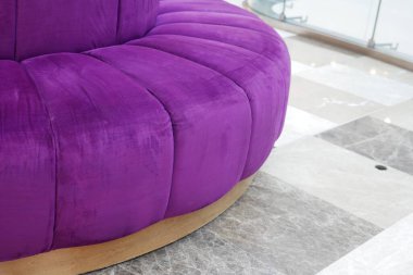 This stylish purple couch features luxurious plush upholstery and a sleek, modern base design clipart