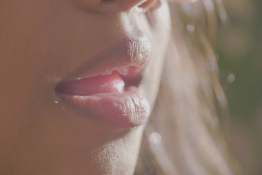 Yakın çekim, yumuşak, esnek dudaklar, doğal ışıkla güzelce aydınlatılmış.