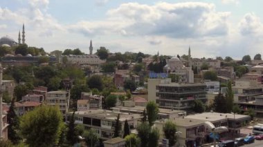 Yeşillik ve fevkalade tarihi yapıların sergilendiği manzaralı bir şehir manzarası.