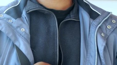 Man zipper on a jacket in cold autumn day. .