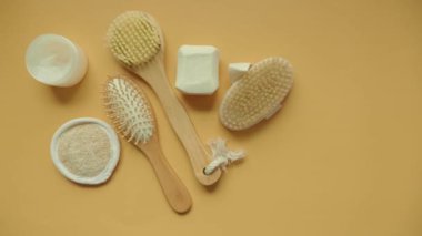 Canlı sarı bir yüzey üzerinde doğal banyo aletleri ve aksesuarlarından oluşan güzel bir koleksiyon.