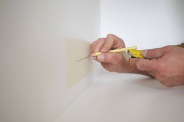 Duvarı mezurayla ölçen adam. .