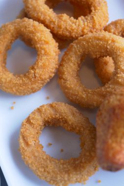 Bir tabak lezzetli ve kızarmış soğan halkası altın kahverengidir ve güzelce servis edilir.