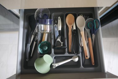 Mutfak çekmecesinde çeşitli mutfak aletleri ve yemek pişirme işleri için gerekli aletler var.