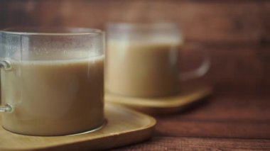 Sıcak bir ortamda, güzel ahşap bardaklara yerleştirilmiş iki fincan çay vardır.