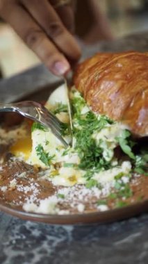 Taze yeşillik ve peynirle dolu lezzetli bir kruvasan sandviçin tadını çıkarın. Her yemek için ideal.