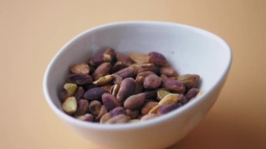 Lezzetli fıstıklarla dolu canlı bir kase. Sağlıklı atıştırmalıklar için mükemmel..