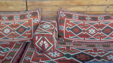 Canlı ve renkli geleneksel tekstil desenleriyle güzelce süslenmiş rahat bir kanepe.