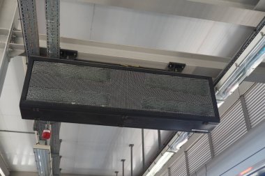 Çağdaş bir endüstriyel ortamda tavandan sarkan bir LED ekran panosu.