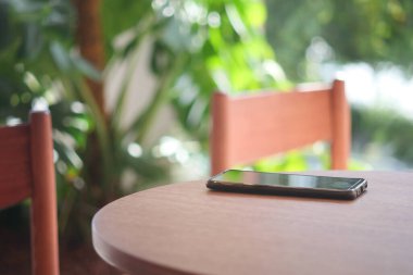 Kafe masasında akıllı telefonu unut, akıllı telefonu kaybet. ,