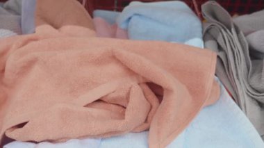 Dokuma sepetinde yumuşak, renkli havlular koleksiyonu. Ev dekorasyonu için mükemmel..