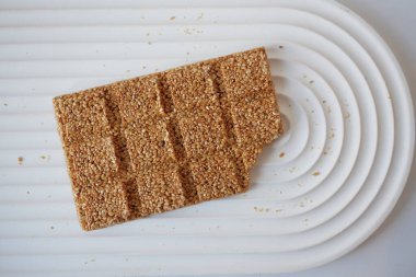 Zarif, modern beyaz bir tezgaha yerleştirilmiş lezzetli bir susamlı büfenin detaylı bir yakın çekimi.