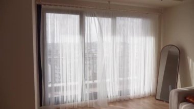 Zarif perdeleri olan parlak bir oturma odası ve ışık için zarif bir ayna.