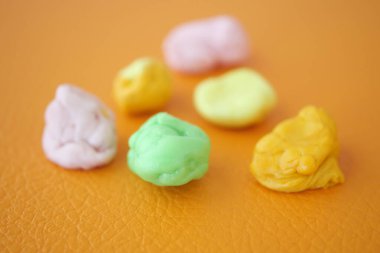 Turuncu arkaplanda renkli baloncuk sakızının yakın plan çekimi 