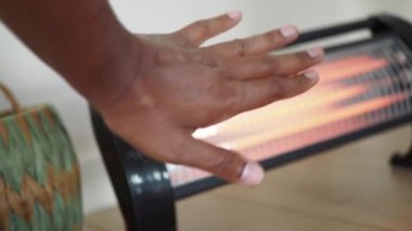 Bir el ısınmak için ısıtıcıya uzanıyor. Sıcak ve davetkar bir ortam.