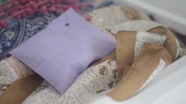 Lavanta kesesi çekmecedeki düzgün düzenlenmiş kıyafetlere dayanır ve yeni bir koku ekler.