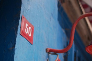 50 numaralı mavi duvara yakın plan ve sanat için canlı kırmızı süslemeler.