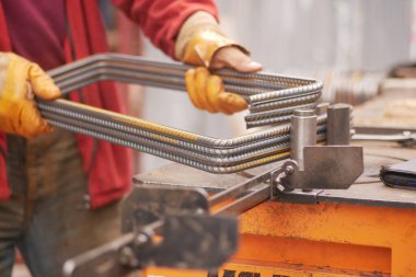 Çok yetenekli bir zanaatkar atölyedeki metal çubukları ustalıkla manipüle eder.