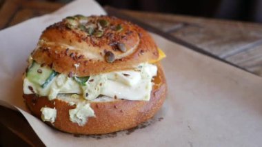 Kremalı malzemelerle dolu ağız sulandıran bir simit sandviçi. Kahvaltı için mükemmel..