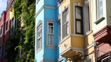 Renkli cepheli şehir mimarisi, canlı balkonlar ve yemyeşil alanlar.