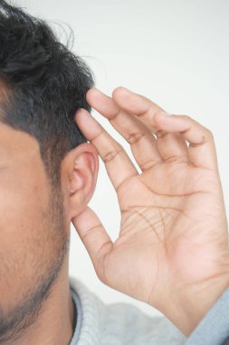 Genç adam acı veren kulağına dokunuyor.