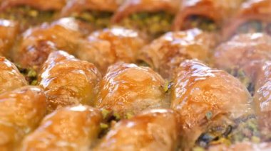 Şam fıstığı kırıntılarıyla serpiştirilmiş otantik baklava dilimlerinin tadını çıkarın.