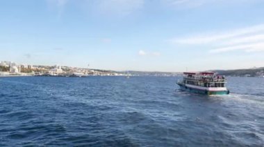 Huzurlu bir tekne kristal berrak sularda güzel bir şehir manzarasına yakın seyreder.