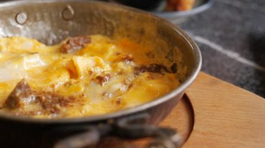 Peynir ve lezzetli etten yapılmış lezzetli ve ağız sulandıran bir omlet, sıcak tavada pişirilmiş.