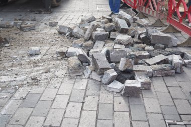 Sokak onarımından sonra kaldırımda gevşek tuğlalar ve dağınık enkaz gözlemlendi.