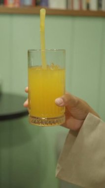 Canlı bir portakal suyu pipetle servis edilir, ferahlatıcı bir yudum için mükemmeldir..