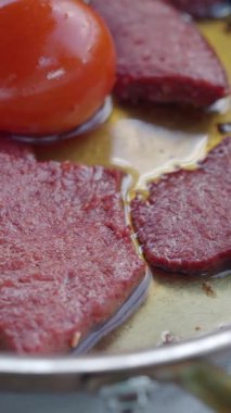 Tahta bir masada tavada kahvaltı sosisi pişirmek.,