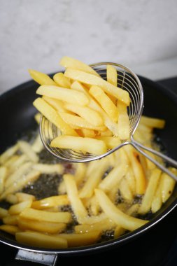 Sıcak yağda pişmiş taze kızarmış patates kızartmasının tadını çıkarın.