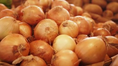 Hareketli bir pazar ortamında canlı ve renkli bir taze soğan gösterisi.
