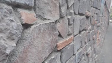 Çeşitli doku ve renklerde güzel inşa edilmiş taş bir duvarın detaylı bir görüntüsü.