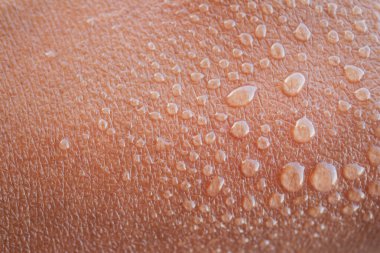 Büyüleyici bir makro çekim. Kalıplı deri yüzeyinde dinlenen su damlacıkları sergileniyor.