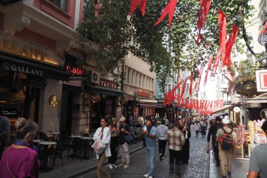 Yayalarla, canlı dekorasyonlarla ve hoş kafelerle dolu hareketli bir cadde.
