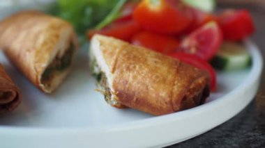 Renkli taze salata karışımının eşlik ettiği kızarmış atıştırmalıkların tadını çıkarın.