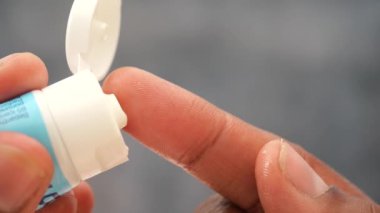 Merheme batırılmış bir parmak, mükemmel bir şekilde hazırlanmış ve cilde uygulanmaya hazır.