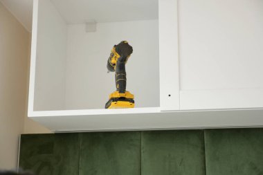 Çok yönlü bir matkap, modern bir mutfak dolabında, kolay erişim için güzelce depolanır.