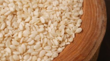 Güzel bir ham beyaz susam tohumu çeşidi zarif bir şekilde ahşap bir kasede düzenlenir.