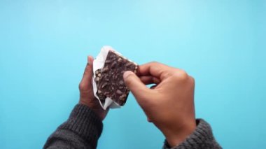Parlak Mavi Arkaplan Karşısında Çikolata Tutan Kişi.