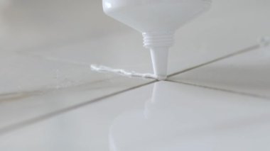 Beyaz Seramik Döşemeler Arasındaki Harç Uygulamasının Kapanışı.