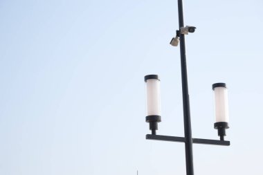 Çağdaş bir sokak lambası. İki silindir lamba ve bir kamera..