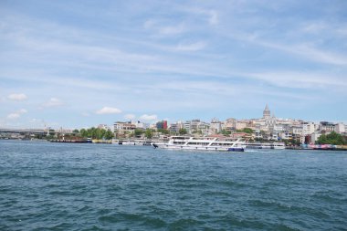 İstanbullar 'ı tekneler ve güzel bulutlu gökyüzü ile çarpıcı kıyı şeridini tecrübe edin.