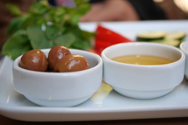 Renkli aperatiflerle dolu canlı bir sıra nefis soslar ve taze, aromatik otlar.