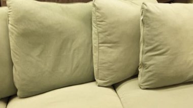 Rahatlamak için yumuşak ve yumuşak yastıklar içeren rahat bir zeytin yeşili kanepe.